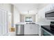 Bright kitchen featuring white cabinets, stainless steel appliances, and a scenic lake view at 9721 Fredericksburg Rd, Tampa, FL 33635