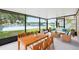 Screened-in patio with comfortable wicker furniture, dining table, and stunning lake views create a relaxing outdoor space at 9721 Fredericksburg Rd, Tampa, FL 33635