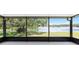Screened lanai offering tranquil views of a lake, lush greenery, and mature trees at 9721 Fredericksburg Rd, Tampa, FL 33635
