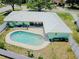 Aerial view of a home with a pool and patio surrounded by a well maintained lawn and pretty landscaping at 1022 Greenbriar Dr, Brandon, FL 33511