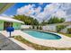 Beautiful pool with stone paver decking, a white fence, and lush landscaping offers a private backyard oasis at 1022 Greenbriar Dr, Brandon, FL 33511
