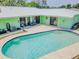 Aerial shot of a beautiful pool with stone paver decking and a light green house at 1022 Greenbriar Dr, Brandon, FL 33511
