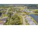 An aerial view of homes surrounding a golf course and community pool featuring lush landscaping at 10801 Collar Dr, San Antonio, FL 33576