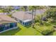 Aerial view of a well-maintained backyard with mature trees, lush green lawn and landscaping at 10801 Collar Dr, San Antonio, FL 33576