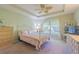 Inviting bedroom with a decorative bed frame, ceiling fan, dresser, and bright natural light at 10801 Collar Dr, San Antonio, FL 33576