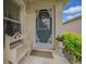 Inviting front porch features decorative door, charming bench, and lush landscaping at 10801 Collar Dr, San Antonio, FL 33576