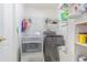 Efficient laundry area featuring a front load washer and dryer, plus shelving for storage at 10801 Collar Dr, San Antonio, FL 33576