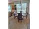 Bright dining area features a round glass table and chairs with views of the verdant golf course at 10908 Sailbrooke Dr, Riverview, FL 33579