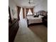 Serene main bedroom with carpet flooring, large windows, and dark wood furniture at 10908 Sailbrooke Dr, Riverview, FL 33579