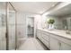 Bright bathroom with double vanity, quartz countertop, a glass shower, and walk-in closet at 1124 Creek Valley Ct, Brandon, FL 33511
