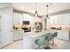 Bright kitchen with white cabinets, quartz countertops, stainless steel appliances, and modern pendant lighting at 1124 Creek Valley Ct, Brandon, FL 33511