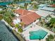 Aerial view of the home featuring a tile roof, landscaped yard, and private pool at 11285 8Th E St, Treasure Island, FL 33706