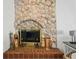 Close-up of stone fireplace with tile hearth and gold accents adding warmth and character to the space at 11285 8Th E St, Treasure Island, FL 33706