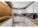Spacious kitchen featuring brick wall accents, wood countertops, white cabinets, and stainless steel appliances at 11285 8Th E St, Treasure Island, FL 33706