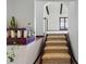 Carpeted staircase featuring wood trim, textured walls, and a decorative display shelf with plants at 11285 8Th E St, Treasure Island, FL 33706