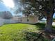 Side view of backyard featuring a large tree and a white fence at 11420 Bridge Pine Dr, Riverview, FL 33569