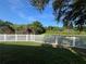 Backyard view featuring green grass and a white fence enclosing a view of natural landscaping at 11420 Bridge Pine Dr, Riverview, FL 33569