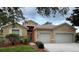 Charming single-story home features a two-car garage and landscaped front yard with a well-maintained lawn at 11420 Bridge Pine Dr, Riverview, FL 33569