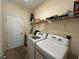 Functional laundry room featuring a modern washer, dryer, and ample shelving space at 11420 Bridge Pine Dr, Riverview, FL 33569