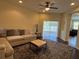 Bright living room features a ceiling fan, sliding glass doors, and comfortable seating area at 11420 Bridge Pine Dr, Riverview, FL 33569