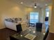 Bright living room with sliding glass doors, a dining area, and a plush sectional sofa at 11420 Bridge Pine Dr, Riverview, FL 33569