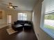 Bright living room with vinyl floors, a ceiling fan, and a dark leather sectional couch at 11420 Bridge Pine Dr, Riverview, FL 33569
