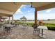 An outdoor seating area with tables and chairs, offering a view of the lush landscape and a water feature at 12672 Fontana Loop, Bradenton, FL 34211
