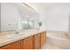 Bright bathroom with double sink vanity, large mirror, soaking tub and tile flooring at 12746 Standbridge Dr, Riverview, FL 33579
