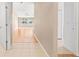 Hallway featuring tile flooring that transitions to hardwood, leading to open living spaces and bedrooms at 12746 Standbridge Dr, Riverview, FL 33579