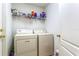 Laundry room features washer, dryer, and shelving for storage at 12746 Standbridge Dr, Riverview, FL 33579