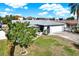 Home featuring a well manicured lawn and large shade tree at 13926 Darlene Ave, Hudson, FL 34667