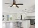 Modern kitchen with stainless steel appliances, a breakfast bar, and bar stools under a decorative ceiling fan at 13926 Darlene Ave, Hudson, FL 34667