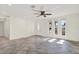 A spacious living room with tile floors, multiple windows, ceiling fan, and decorative front door create a welcoming atmosphere at 13926 Darlene Ave, Hudson, FL 34667