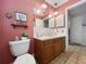Bathroom featuring a toilet, vanity with sink and pink walls at 14321 113Th Ave, Largo, FL 33774