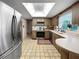 Bright kitchen featuring tile floors, stainless steel appliances, and a skylight at 14321 113Th Ave, Largo, FL 33774