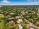 Expansive aerial view of a luxury home with a pool nestled among lush greenery in a vibrant neighborhood at 1470 Serpentine S Dr, St Petersburg, FL 33705