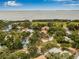 Expansive aerial view of a luxury home with a tile roof nestled among lush greenery near the bay at 1470 Serpentine S Dr, St Petersburg, FL 33705