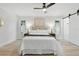 Well-lit bedroom with a ceiling fan, a comfortable bed, and light hardwood flooring at 1470 Serpentine S Dr, St Petersburg, FL 33705