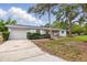 Charming one-story home featuring a bright yellow front door, lush landscaping, and mature trees at 1470 Serpentine S Dr, St Petersburg, FL 33705