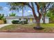 Charming single-story home featuring a bright yellow front door, brick accents, and lush landscaping at 1470 Serpentine S Dr, St Petersburg, FL 33705