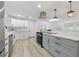 Modern eat-in kitchen featuring stainless steel appliances, light gray cabinets, and light-colored flooring at 1470 Serpentine S Dr, St Petersburg, FL 33705