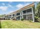 Low-angle view of a multi-story condo building with well-maintained landscaping and screened in porches at 1485 Lakeview Rd # 19, Clearwater, FL 33756
