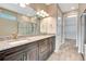 The bathroom features dual sinks, granite countertops, glass shower and entry to a walk-in closet at 16723 Blackwater Ter, Bradenton, FL 34202