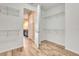 Large walk-in closet with wood-look tile floors, and shelving; bathroom with granite counters visible through the doorway at 16723 Blackwater Ter, Bradenton, FL 34202