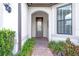 Leaded glass front door with sidelight surrounded by green landscaping and a brick walkway at 16723 Blackwater Ter, Bradenton, FL 34202