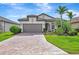 Beautiful home featuring a paved driveway, a two-car garage, and lush landscaping at 16723 Blackwater Ter, Bradenton, FL 34202