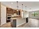 Kitchen area showcasing dark wood cabinets, pendant lights, granite countertops, and stainless appliances at 16723 Blackwater Ter, Bradenton, FL 34202