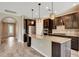 Stunning kitchen with dark cabinets, granite countertops, stainless steel appliances, and wood tile flooring at 16723 Blackwater Ter, Bradenton, FL 34202