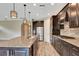 Modern kitchen with granite countertops, stainless steel appliances, dark cabinets, and wood-look tile flooring at 16723 Blackwater Ter, Bradenton, FL 34202