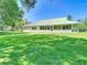 Expansive backyard featuring a green metal roof, lush green grass, and mature trees at 1914 Henley Rd, Lutz, FL 33558